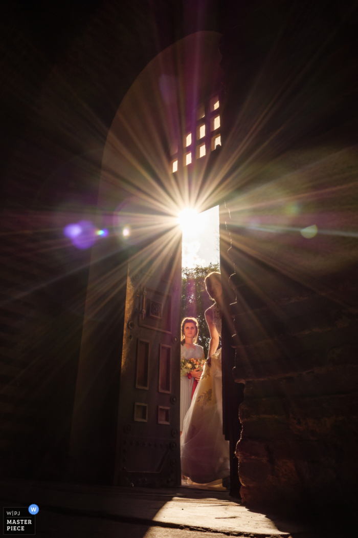 Fotografía de la boda de Bulgaria en la iglesia de Santa Sofía de la novia y la dama de honor, ingrese al vestíbulo de la iglesia para esperar el comienzo de la ceremonia.