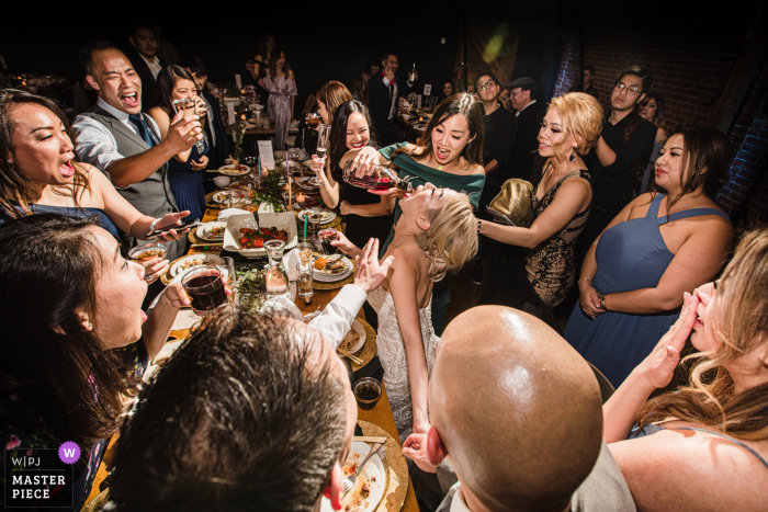 Foto di matrimonio in California da San Jose di ospiti che restituiscono il favore acquistano colpi di cognac alla sposa. Questo matrimonio è stato l'ultimo scatto di nozze prima della chiusura della pandemia