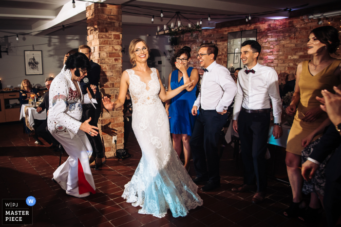 A Lodzkie wedding photographer captured this image at the Best Western Podklasztorze in Sulejow, Poland - Disguised as Elvis, the musician chases the bride during one of the wedding dances