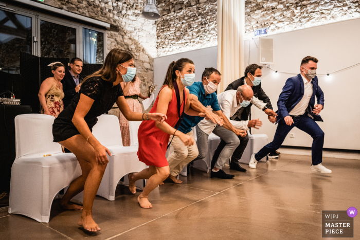 Un fotografo di matrimoni di Parigi ha catturato un momento al Domaine de Mauvoisin, Lommoye, Francia mentre gli ospiti corrono per una partita durante la cena