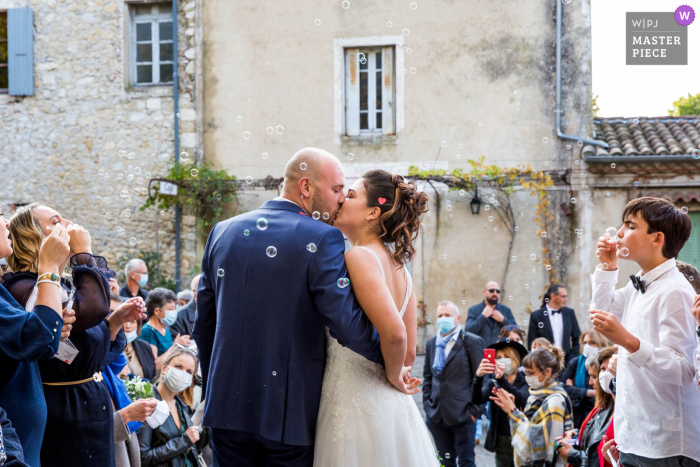 Fotograf ślubny z Ardeche uchwycił ten pocałunek pary Auvergne-Rhône-Alpes przed kościołem