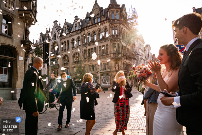 Vlaams Brabant huwelijksfotografie van het koppel buiten in het Stadhuis Gent met een beetje magie in 2020 met COVID maskers op