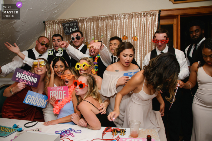 Fotografía de la boda de Carolina del Norte de The Currituck Club, Corolla, NC de una bebida derramada mientras los miembros de la fiesta de bodas toman una foto divertida