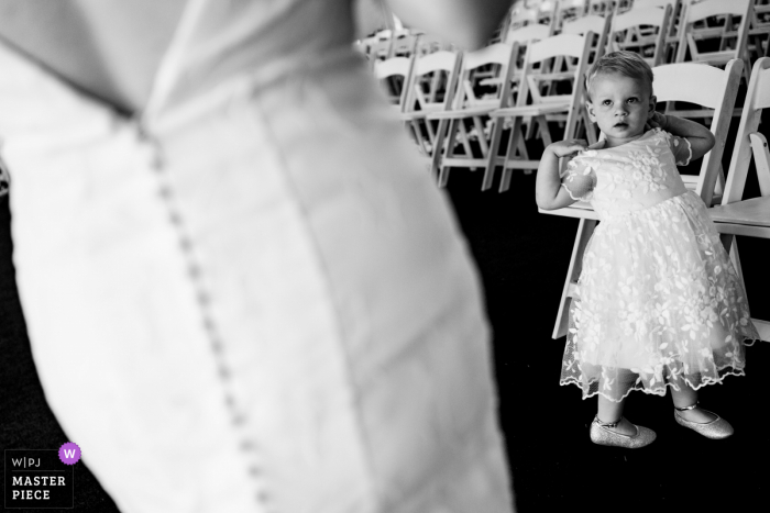 Georgia wedding photography from Atlanta of a young girl admiring the bride and her dress at the outdoor ceremony venue Georgia wedding photography from Atlanta of a young girl admiring the bride and her dress at the outdoor ceremony venue