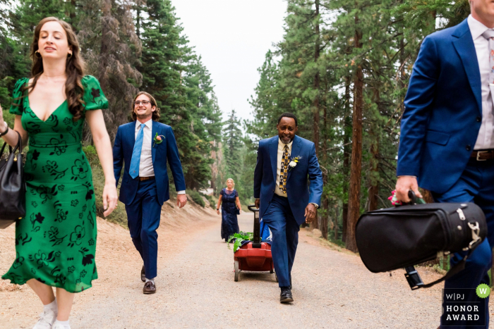 Fotografia di matrimonio all'aperto in Nevada da Incline Village, NV mentre i membri della famiglia Immediate tirano un carro di oggetti fino a un belvedere di montagna in preparazione per una covid fuga d'amore a Lake Tahoe, NV