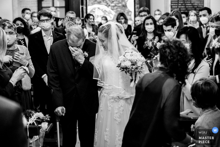 El fotógrafo de bodas Verbano-Cusio-Ossola capturó esta imagen de la ceremonia de la Iglesia de Piamonte de La llegada de la novia con su abuelo