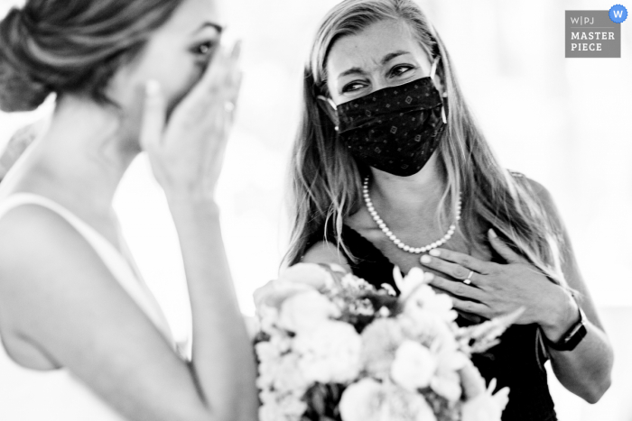 Fotógrafo de bodas de DC tomando fotografías en L'auberge Chez François en Falls Church, Virginia de La novia riendo con su mejor amiga después de la ceremonia de la boda.