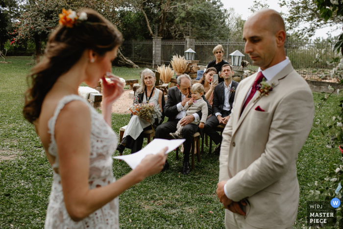 Rio Grande do Sul outdoor ceremony wedding photo at the grooms house	showing the Father of the bride asking the child to be silent