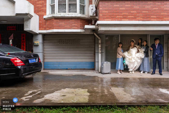 Jinhua trouwreportages uit Zhejiang bij de bruidegom thuis. Het stel wacht op de auto om naar het hotel te gaan