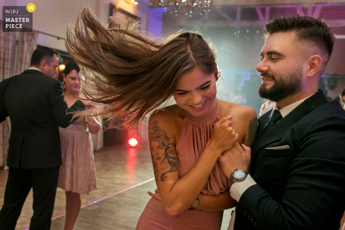 Fotografia di matrimonio di Cracovia dal luogo di ricevimento Malopolskie di un ospite che balla con i capelli in aria