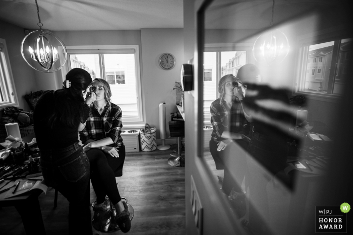 Alberta creative wedding photo of the Bride reflected in glass during makeup