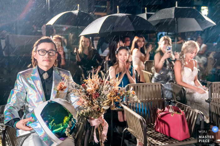 La foto del matrimonio dello sposo del Taipei Marriott Hotel e degli ospiti stavano aspettando la sposa sotto una grande pioggia