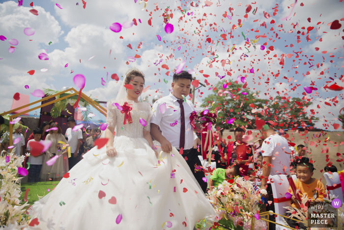 Shaanxi wedding photo showing Petals and newcomers are beautiful at this outdoor marriage ceremony under the clouds