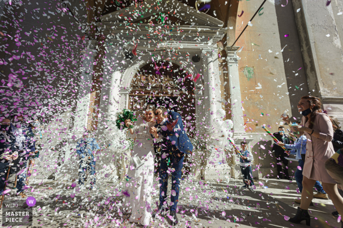 Trouwfoto van de trappen van de kerk van St.Mary of the Assumption, Gavardo (Bs) met het gooien van confetti op de pasgetrouwden