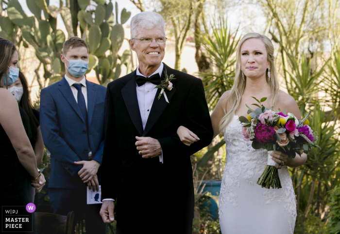 Foto de casamento ao ar livre no Arizona, no Hacienda del Sol Resort - Tucson, AZ, mostrando a noiva caminhando pelo corredor do jardim com o pai