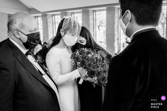 Das Hochzeitsfoto von College Station, TX zeigt Mama und Papa, die einen emotionalen Moment erleben, bevor sie ihre Tochter während einer kirchlichen Zeremonie weggeben