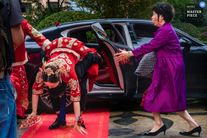 China trouwfoto van de bruidegom die de bruid op de rode loper laat vallen - Accepteer familieleden