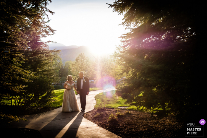 Hochzeitsfoto vom Broadmoor Hotel in Colorado Springs, wo die Hochzeit und der Empfang stattfanden, als das Paar von der Hochzeitszeremonie zum Abendessen am Empfang ging