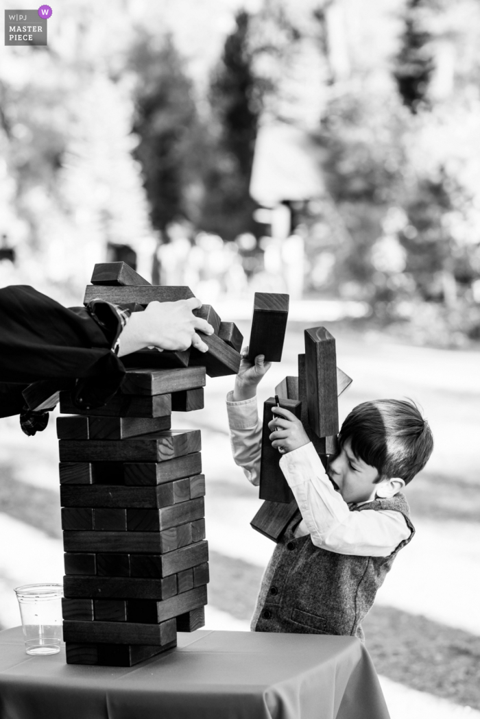 Incline Village, NV wedding photo showing a Jenga game going in an unexpected direction upon a child's head during a wedding reception in Lake Tahoe