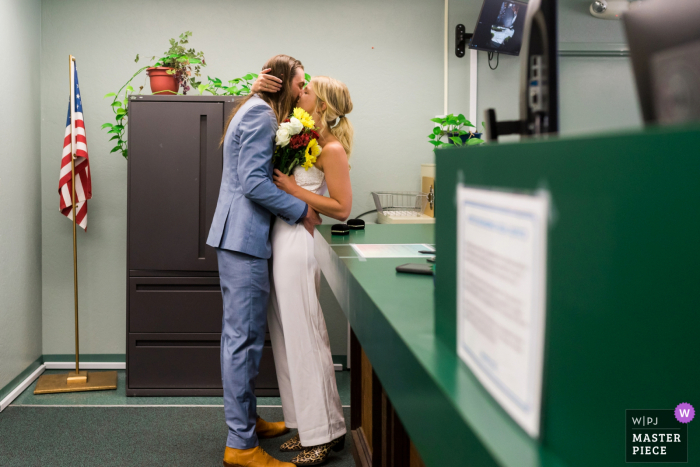 Imagem da noiva e do noivo dando seu primeiro beijo no escritório do County Clerk após a cerimônia civil em South Lake Tahoe, CA