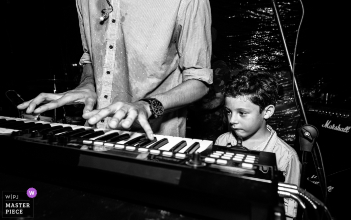 Alagoas Hochzeitsfoto von einer Empfangsparty in Brasilien, auf dem ein kleines Kind den Keyboarder beobachtet