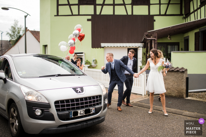 Foto de Bas-Rhin creada entre el ayuntamiento y la casa de la pareja en su camino de regreso a casa después de la ceremonia civil. Coche tocando la bocina y el novio celebrando su alegría como un mundial de fútbol