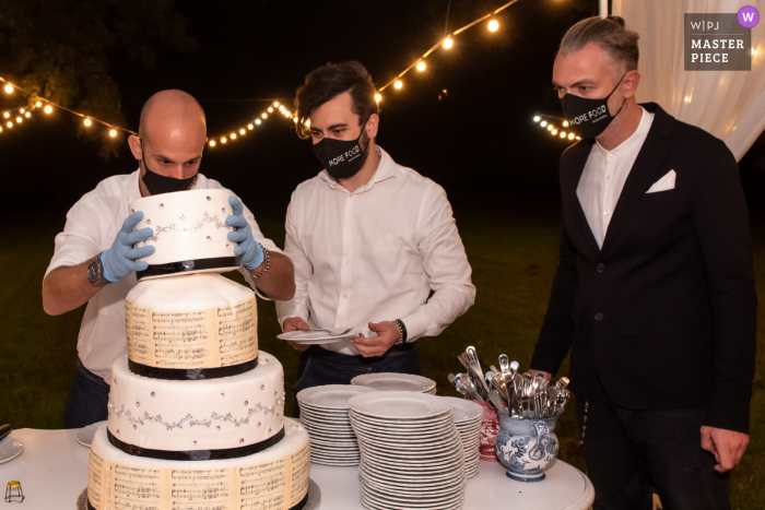 Hochzeitsbild der Rezeption aus der Villa Angeli - Pegognaga - Mantua - Italien: Unter der Leitung des Maitre d versucht die Person, die für die Aufteilung der Portionen für die Gäste zuständig ist, die Böden mit der gleichen Aufmerksamkeit und Langsamkeit wie ein Blaster zu zerlegen