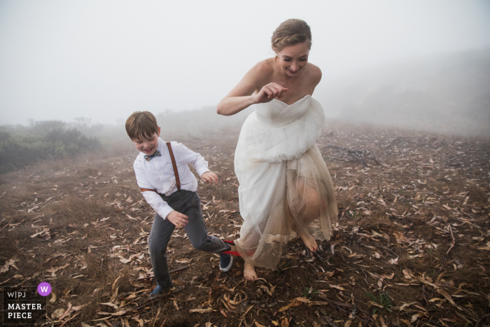 CA wedding photo from Stinson Beach showing the bride and her new son taking part in a three-legged race