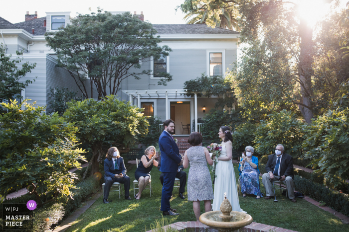 Trouwfoto van de ceremonieplaats in de Gamble Gardens in Palo Alto, Californië met het prachtige licht dat door de bomen stroomt geeft een gevoel van hoop en doorzettingsvermogen