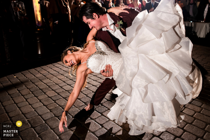 Colorado Hochzeitsempfangsfoto von Della Terra Mountain Chateau (Estes Park, CO) des Bräutigams, der Braut während des ersten Tanzes eintaucht