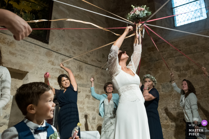 Photo by: <a href="https://www.wpja.com/contests/2020-v05/best-wedding-photographers/2609039">Valerie Teppe - Limoges </a> Turenne The bouquet cutting ribbons wedding photo from the reception party