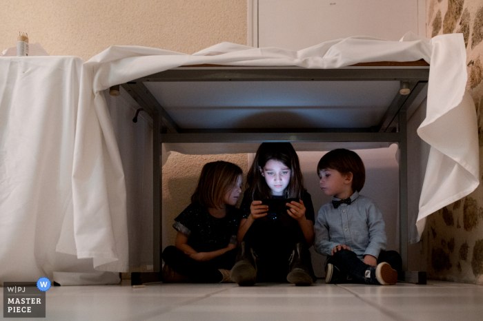 Trouwfoto van het receptiefeest bij Taysse vijvers van Kinderen met ipad tijdens het diner