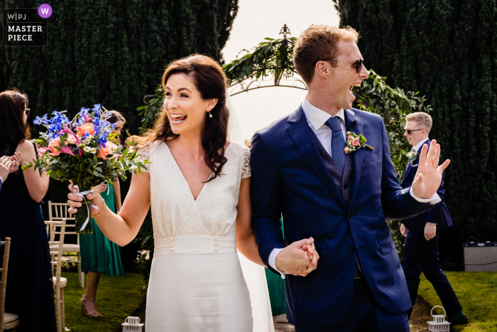 Foto da reportagem do casamento na Irlanda da Gloster House, Offaly mostrando a noiva e o noivo celebrando o fato de serem recém-casados