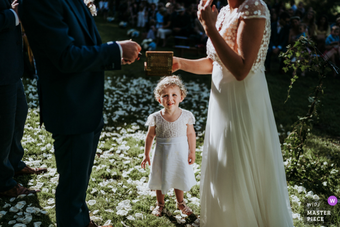 Foto di matrimonio all'aperto, in giardino dal castello di Sauveboeuf Dordogne Francia di Una bambina che guarda i suoi genitori sposarsi