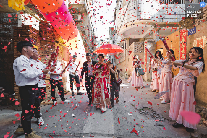 Photo by: <a href="https://www.wpja.com/contests/2020-v05/best-wedding-photographers/2609334">Asaph Xu - Quanzhou </a> Quanzhou Fujian wedding photography of the bride walking under confetti with a red umbrella