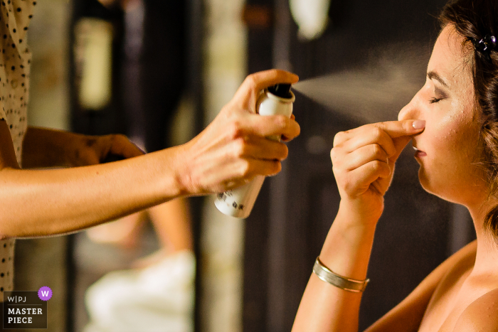 Fotografía de boda de Borgo San Faustino, Orvieto que muestra a la maquilladora terminando su trabajo con la novia