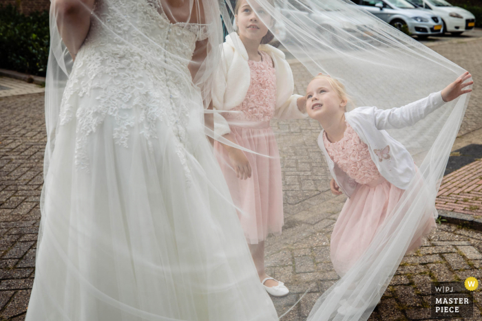 Noord Brabantse trouwfoto van kleine meisjes onder de sluier met de bruid