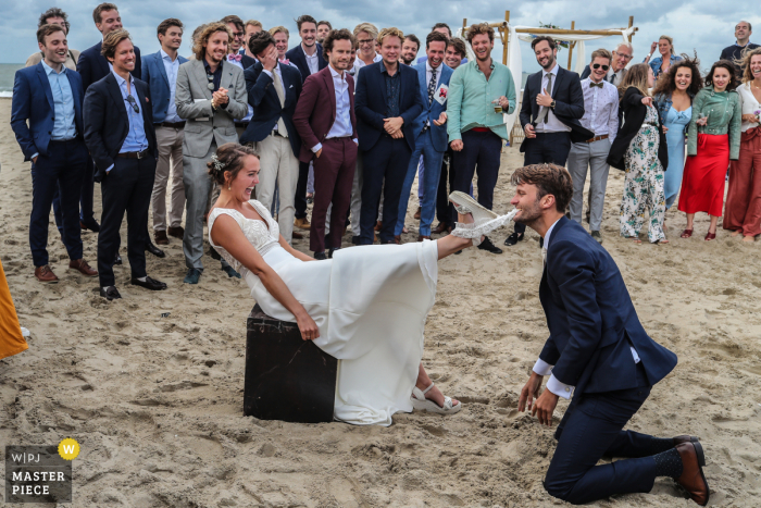 Foto do casamento de Noord Holland na praia de Scheveningen, com a liga sendo recuperada pelo noivo