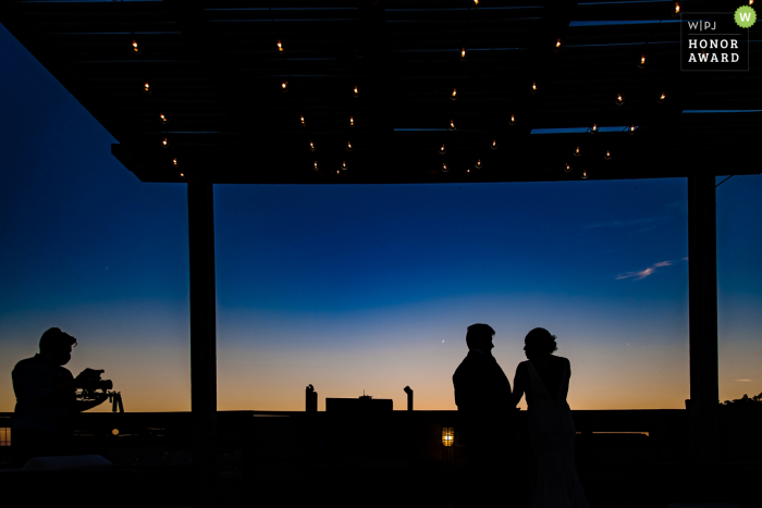 Illinois wedding reception photo at night showing a Chicago couple chatting on the roof Chicago Illinois wedding reception photo at night showing a Chicago couple chatting on the roof
