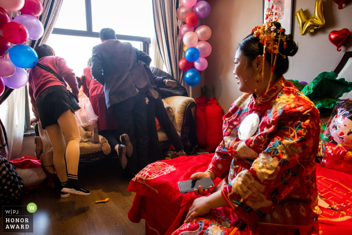 Jinhua-trouwfoto uit Zhejiang bij het huis van de bruid toen De bruidegom beneden was van het huis van de bruid en de gasten van het huis van de bruid door het raam kijken