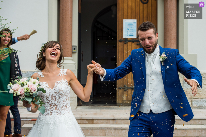 Fotografia di matrimonio dalla scalinata del municipio di Chapareillan, Francia con gli sposi sotto una pioggia di coriandoli al termine del rito civile