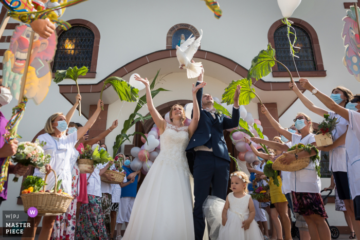Wedding photo of the dove release at the Bas-Rhin Church near the end of ceremony Wedding photo of the dove release at the Bas-Rhin Church near the end of ceremony