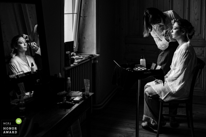 French black and white wedding photo from Auvergne-Rhône-Alpes of the bride who gets made up with her reflection in the mirror