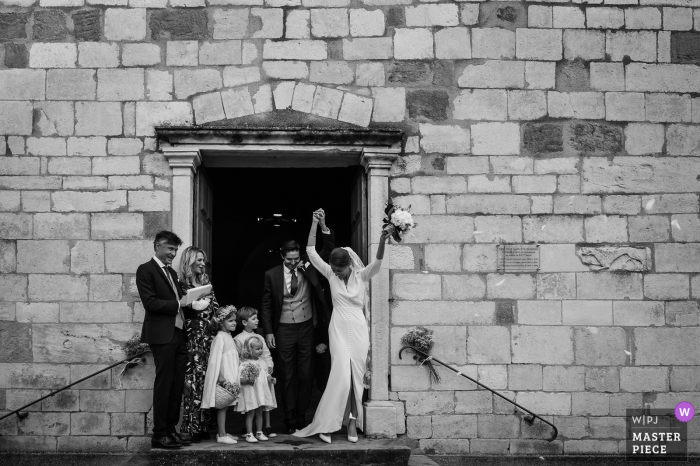 Foto de boda de Lyon fuera de una iglesia de Auvergne-Rhône-Alpes de la pareja feliz saliendo del edificio