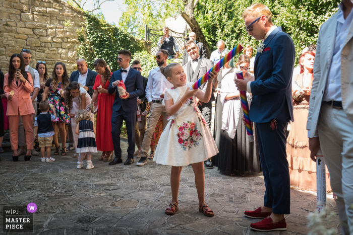 Fotografia de casamento em Ancona, de Chiesa di Sant'Elena, de uma criança com um canhão de confete sem boom