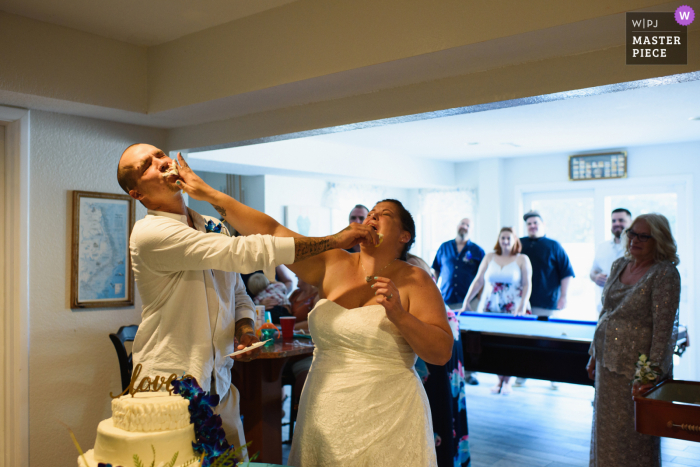 Photo de réception de mariage en Caroline du Nord de Corolla of the Bride and Groom smashing cake in each other's faces