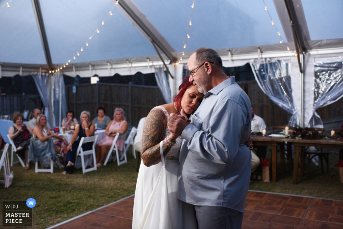 Foto de la boda de Carolina del Norte de South Nags Head que muestra que la novia está emocionada mientras baila con su padre