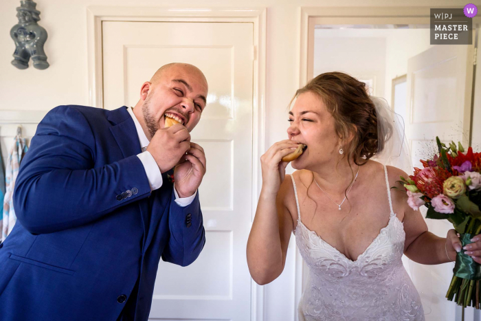 Una sposa e uno sposo olandesi stanno mangiando un "worstenbroodje / sandwich di carne" Una tipica tradizione di matrimonio olandese nello stato del Brabante