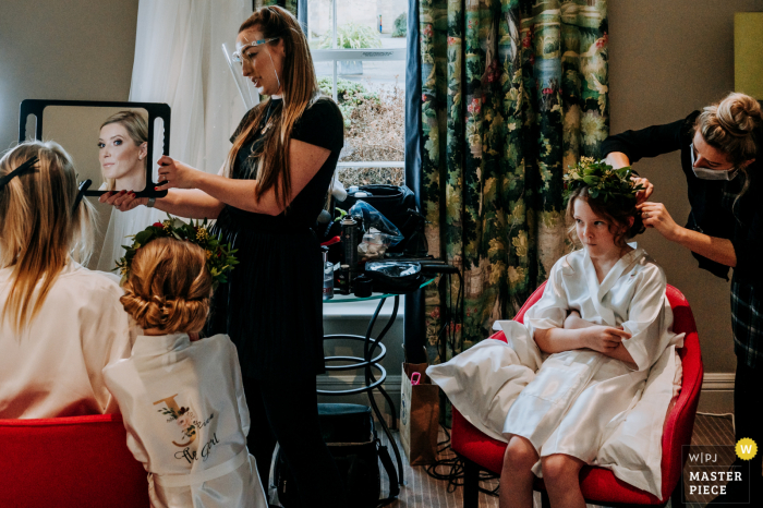 Harrogate, North Yorkshire, Reino Unido, imagem do casamento da noiva se preparando de manhã, com a filha olhando para a mãe (a noiva) enquanto se admira no espelho