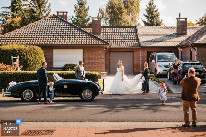 Foto de la boda de Amberes de la novia saliendo de su casa justo antes de conocer a su esposo para el primer vistazo.